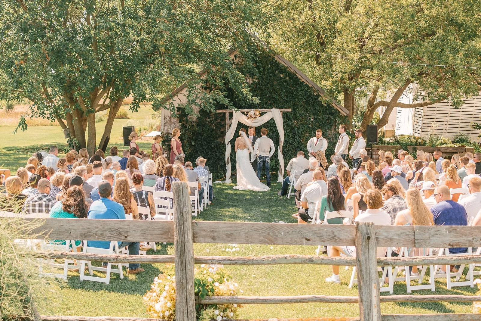 Outdoor wedding ceremony under the trees at Huser Farm, a rustic Wisconsin wedding venue